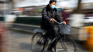 A man wearing a face mask rides a bicycle, as the country is hit by an outbreak of the novel coronavirus, in Beijing, China February 12, 2020.