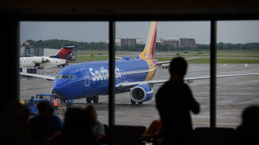 A person watches as a Southwest Airlines Co. plane arrives at a gate at the Pittsburgh International Airport (PIT) in Moon Township, Pennsylvania, U.S., on Tuesday, July 2, 2019.