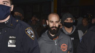 Mac's Public House co-owner Danny Presti is taken away in handcuffs after being arrested by New York City sheriff's deputies