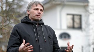 Fabian Leendertz speaks during an interview, with building in the background