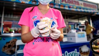 Dippin Dots employee with a cup of Rainbow Ice