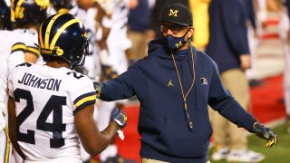 PISCATAWAY, NJ - NOVEMBER 21: Michigan Wolverines head coach Jim Harbaugh talks with Michigan Wolverines defensive back George Johnson (24) during warm up prior to the college football game between the Rutgers Scarlet Knights and the Michigan Wolverines on November 21, 2020 at SHI Stadium in Piscataway, NJ.