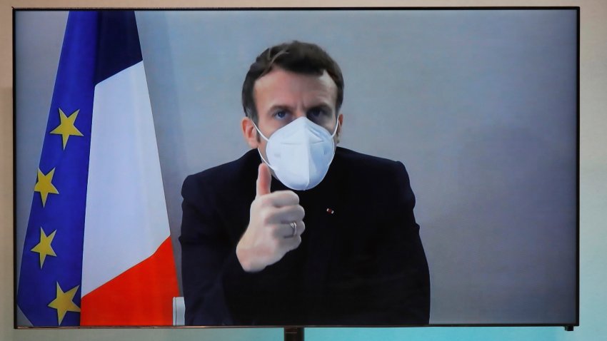 French President Emmanuel Macron is seen on a screen as he attends by video conference a round table for the National Humanitarian Conference (NHC), taken at the Foreign Ministry in Paris, Thursday, Dec. 17, 2020. French President Emmanuel Macron tested positive for COVID-19 Thursday following a week in which he met with numerous European leaders. The French and Spanish prime ministers and EU Council president were among many top officials self-isolating because they had recent contact with him.
