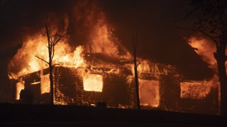 A house is seen burst into flames during the Zogg fire.