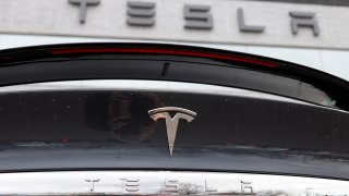 A 2020 Model X sits in front of a Tesla dealership in Littleton, Colorado, April 26, 2020. An investigation from the National Transportation Safety Board, sparked by crashes that all involved Tesla vehicles, says there are too little guidelines for first responders dealing with fires caused by high-voltage lithium-ion batteries used by electric cars.