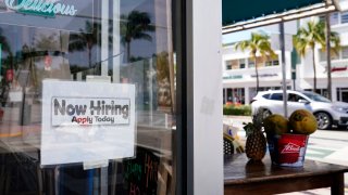 A "Now Hiring," sign is shown in the window of a restaurant, Thursday, Jan. 7, 2021, in Miami Beach, Florida. America's employers likely cut back on hiring last month, and may have even shed jobs, as the economy suffers from a resurgent virus that has caused many consumers to cut back on spending and states and cities to reimpose business restrictions.