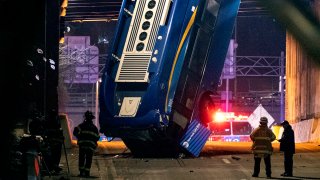 A bus in New York City which careened off a road in the Bronx neighborhood of New York and is left dangling from an overpass, Jan. 15, 2021, after a crash late Thursday that left the driver in serious condition, police said.