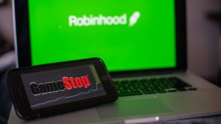 The GameStop Corp. logo on a smartphone and the Robinhood website on a laptop