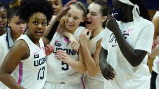 Connecticut guard Nika Muhl (10) hugs guard Paige Bueckers (5) after defeating South Carolina in overtime of an NCAA college basketball game in Storrs, Conn., in this Monday, Feb. 8, 2021, file photo.