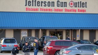 METAIRIE, LA - FEBRUARY 20: Investigators with the Jefferson Parish Sheriffs Office look at a shell casing in the parking lot of the Jefferson Gun Outlet as investigators work the scene on February 20, 2021 in Metairie, Louisiana. According to reports, three people were killed and two injured after an altercation lead to gunfire at an indoor shooting range.