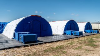 Intensive care tents sit in a row at a Influx Care Facility (ICF) for unaccompanied children on Sunday, Feb. 21, 2021 in Carrizo Springs, TX.