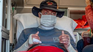 SANTA ANA, CA - FEBRUARY 17: Dylan Van Iwaarden, an Orange County Fire Authority hand crew firefighter, gives the thumbs up after being loaded into the ambulance as he leaves the Orange County Global Medical Center for rehab in Santa Ana on Wednesday, February 17, 2021. Van Iwaarden spent 114 days in the Orange County Burn Center after he was severely burned fighting the Silverado Fire on October 26, 2020.