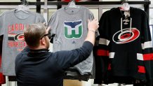 Kurt Cusac, a worker at The Eye store, straightens out the Hartford Whalers tee shirts before the doors open before an the Carolina Hurricanes play host to the Montreal Canadiens at PNC Arena in Raleigh, N.C., on Thursday, Feb. 1, 2018. It's the first time items from the team's former identity are being sold, a change brought about by the Canes' new owner, Tom Dundon. (Chris Seward/Raleigh News & Observer/Tribune News Service via Getty Images)