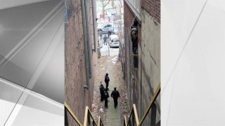 Police respond to the scene of an alleged thief clinging to the side of a building