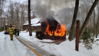 flames shoot from the garage of a home in Deep River