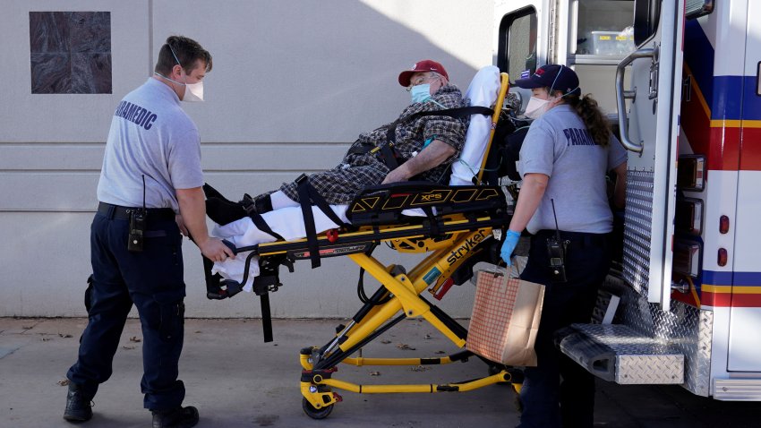 REACT EMS paramedics wearing protective masks unload a potential coronavirus disease (COVID-19) patient at the ER in Shawnee, Oklahoma, U.S. December 20, 2020.