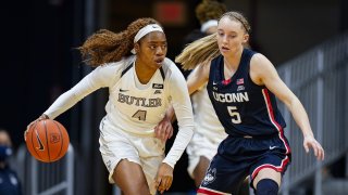 Butler guard Okako Adika (4) drives on Connecticut guard Paige Bueckers (5) during the first quarter of an NCAA college basketball game in Indianapolis, Saturday, Feb. 27, 2021.