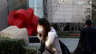 a woman walks past a Dolce&Gabbana retail outlet in Beijing, China