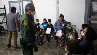 Migrants are processed at the intake area of the U.S. Customs and Border Protection facility, the main detention center for unaccompanied children in the Rio Grande Valley, in Donna, Texas, Mar. 30, 2021.