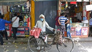 A man with his bicycle on a street in the old quarters of New Delhi on April 19, 2021, as India’s capital will impose a week-long lockdown from tonight, officials said, while the megacity struggles to contain a huge surge in Covid-19 cases with hospitals running out of beds and oxygen supplies low.