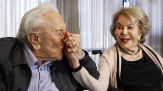 In this May 4, 2017, file photo, Kirk Douglas kisses his wife Anne's hand, in Los Angeles during a party celebrating his 100th birthday. Anne Douglas, the widow of Kirk Douglas and stepmother of Michael Douglas, died Thursday, April 29, 2021, in California. She was 102. Douglas died at her home in Beverly Hills, according to an obituary provided by spokeswoman Marcia Newberger. No cause of death was given.