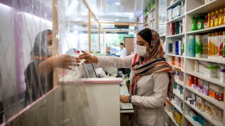 A staff member wearing a face mask works at a pharmacy in Tonekabon, Iran, on April 26, 2021.