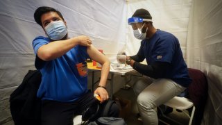 A commuter rolls up his sleeve to receive a vaccination shot for the coronavirus disease (COVID-19) at Grand Central Station Terminal train station in Manhattan in New York City, New York, U.S., May 12, 2021.