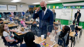 In this May 3, 2021, photo, President Joe Biden gestures as he talks to students during a visit to Yorktown Elementary School, in Yorktown, Va., as first lady Jill Biden watches. Biden has met his goal of having most elementary and middle schools open for full, in-person learning in his first 100 days.
