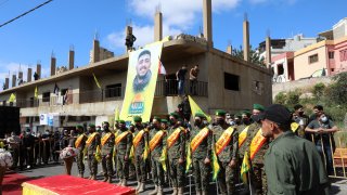 Members of the Iran-backed Hezbollah movement, surround the coffin of Mohamad Kassem Tahan, a fellow member killed a day earlier by Israeli shelling on the frontier with Lebanon during a protest against the latest assault on the Gaza Strip, at his funeral in the southern Lebanese village of Adloun, on May 15, 2021.