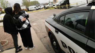 COLORADO SPRINGS, COLORADO - MAY 9: A neighbor, left, comforts a family member of some of the six shooting victims outside the scene of the shooting at the Canterbury Mobile Home Park on May 9, 2021 in Colorado Springs, Colorado. A gunman killed six people at a family birthday party before taking own life, police said. The victims were all members of the same extended family a party attendee said. The shooting was in the 2800 block of Preakness Way in the Canterbury Mobile Home Park. The shooting happened just after midnight. Colorado Springs police Lt. James Sokolik said in a news release. Investigators believe the shooter, who has not been publicly identified, was the boyfriend of a woman at the party.