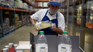 An employee fills cups with samples of Costco Wholesale Corp. Kirkland Signature brand organic lemonade