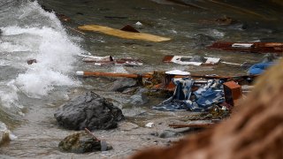 Wreckage and debris from a capsized boat wash ashore at Cabrillo National Monument near where a boat capsized just off the coast, May 2, 2021, in San Diego.