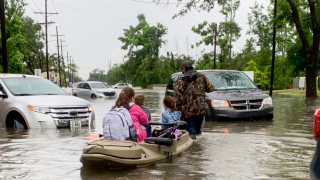 Parents use boats to pick up students from schools after nearly a foot of rain fell in Lake Charles, La., on May 17.