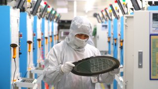 Employees work on the production line of silicon wafer at a factory of GalaxyCore Inc. on May 25, 2021 in Jiashan County, Jiaxing City, Zhejiang Province of China.