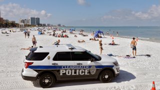 police officers patrol the area after Clearwater Beach officially reopened to the public in Clearwater Beach, Fla.