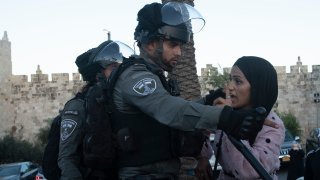 An Israeli border police officer faces off with a Palestinian woman at a protest at the Damascus Gate to the Old City of Jerusalem Thursday, June 17, 2021 against incendiary chants used by ultranationalist Israelis at their "Flags March" at the same site on Tuesday.