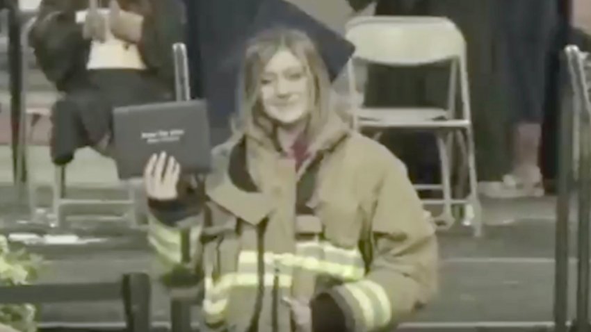 The daughter of a firefighter killed in a fire station shooting wears her father's turnout gear at her high school graduation.