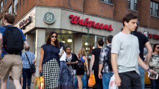 Pedestrians walk past a Walgreens store in New York.