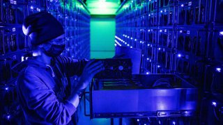 An engineer inspects a Sapphire Technology Ltd. AMD graphics processing unit (GPU) at the Evobits crypto farm in Cluj-Napoca, Romania, on Wednesday, Jan. 22, 2021.