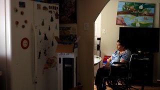 Francisca Perez, 84, sits by the dining table on a wheelchair in her house in Chicago's Little Village neighborhood