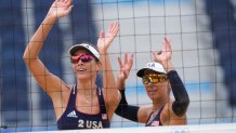 April Ross, right of the United States, and teammate Alix Klimeman wave after winning a women's beach volleyball match against Spain at the 2020 Olympics on July 27, 2021, in Tokyo, Japan.