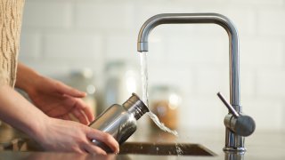glass of water is filled at a kitchen tap