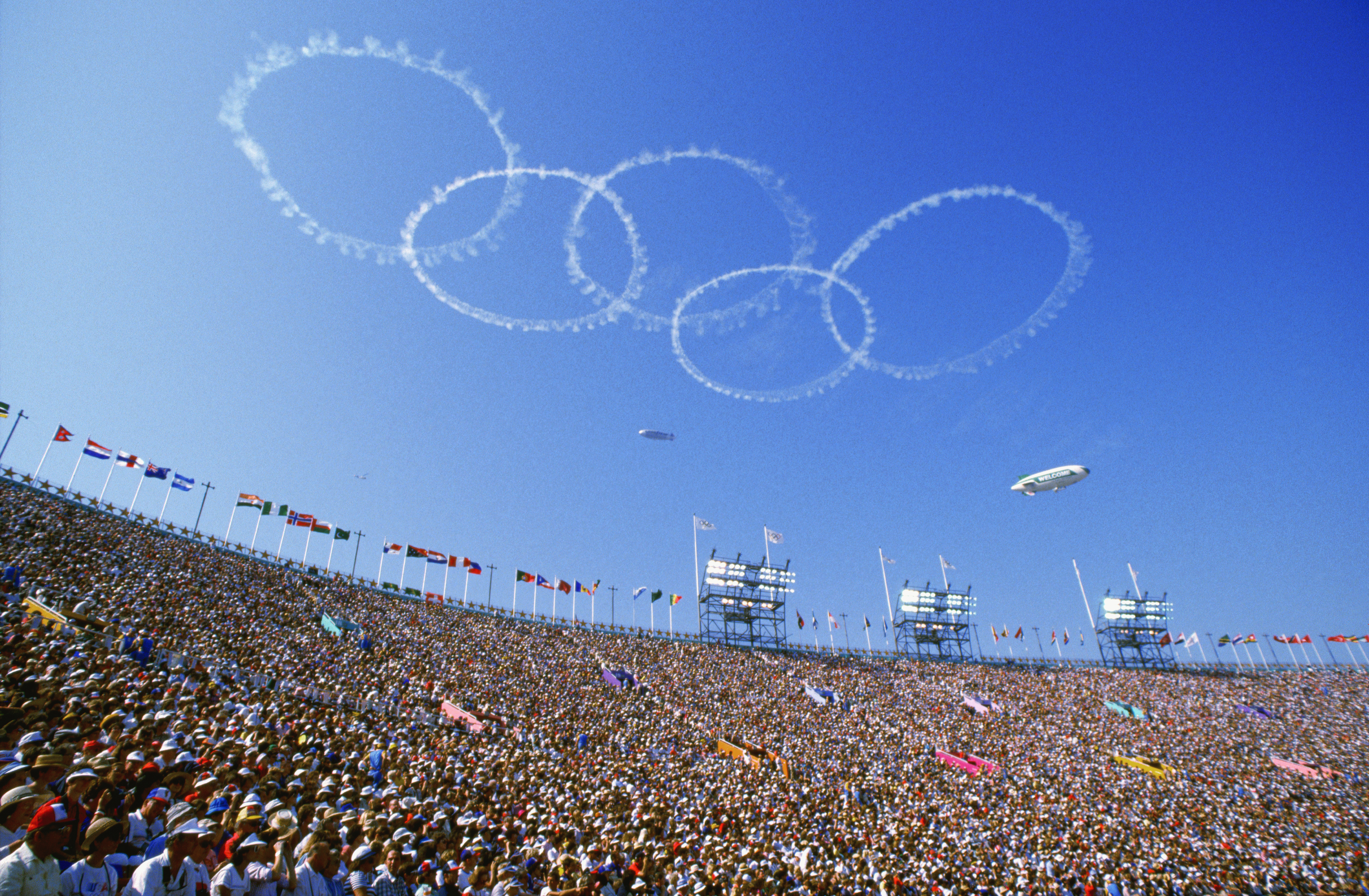 Olympic rings of smoke appear above the crowd. (Photo by © Kit Houghton/CORBIS/Corbis via Getty Images)