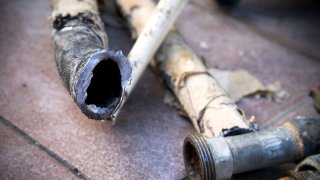 Close-up of disconnected old lead pipe.