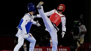 South Korea's Lee Daehoon (Blue) and Uzbekistan's Ulugbek Rashitov (Red) compete in the taekwondo men's -68kg elimination round bout during the Tokyo 2020 Olympic Games at the Makuhari Messe Hall in Tokyo on July 25, 2021.