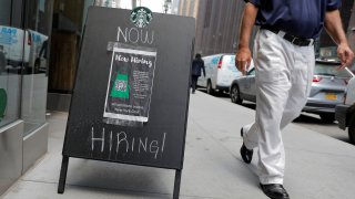 A sign advertising job openings is seen outside of a Starbucks in New York, May 26, 2021.
