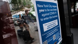 A sign in a restaurant window informs customers that they will need to show proof that they are at least partly vaccinated for Covid-19 to be allowed in the business on August 20, 2021 in New York City.