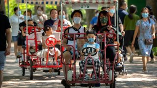 Adults and children ride pedal cycles