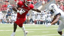 Fresno State running back Jordan Mims, left, stiff-arms a Connecticut defender during the first half of an NCAA college football game in Fresno, Calif., Saturday, Aug. 28, 2021.