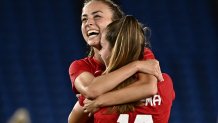 Canada's midfielder Julia Grosso, left, hugs forward Jordyn Huitema after scoring the winning penalty during the penalty shoot-out of the Tokyo 2020 Olympic Games women's final football match between Sweden and Canada at the International Stadium Yokohama in Yokohama on Aug. 6, 2021.